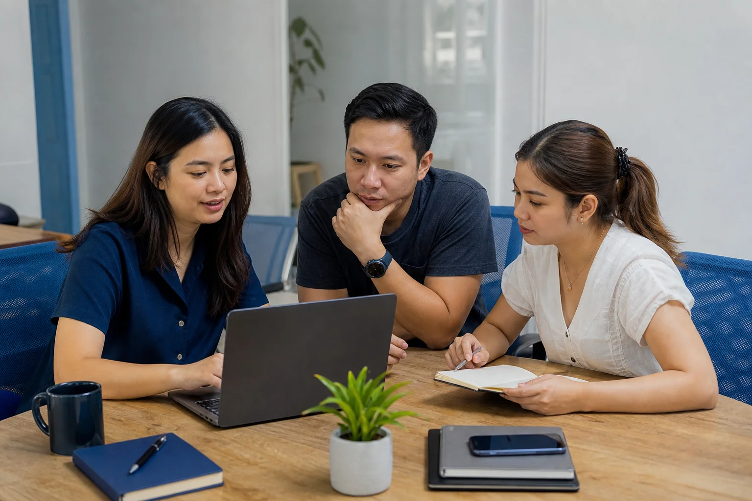 A team working together around a table with laptops and notes.